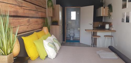 a room with a couch with pillows and a kitchen at NORTH in Jastrzębia Góra