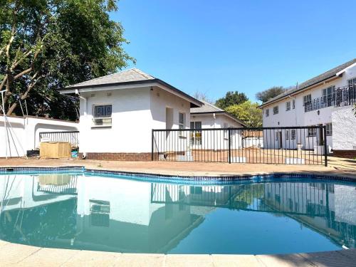 a swimming pool in front of a house at CHIC Guest House & Solar system accommodations in Germiston