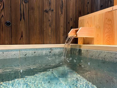 uma piscina com uma fonte de água em Rinn Rokujo Machiya em Quioto