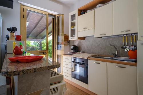 a kitchen with white cabinets and a counter top at Villa Rita a 200m dal mare in I Bacini