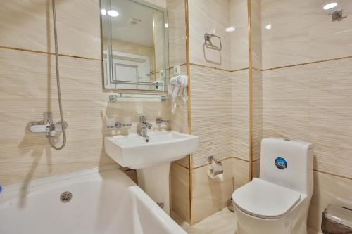 a bathroom with a sink and a toilet and a bath tub at Asian Plaza in Bukhara