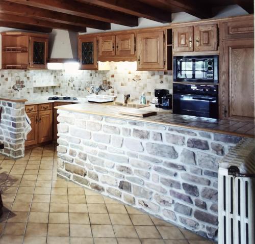 eine Küche mit einer Steinmauer in der Mitte in der Unterkunft Maison Encantalou 