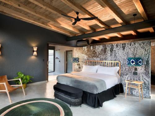 sypialnia z dużym łóżkiem i drewnianym sufitem w obiekcie Mbazo Safaris w mieście Pilanesberg
