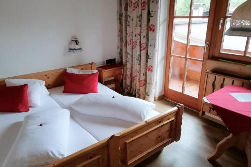 two beds in a room with a window at Hotel Gut Kramerhof in Kirchdorf in Tirol