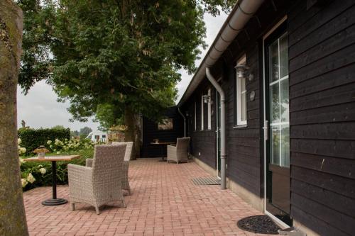 a patio with chairs and a table next to a building at Boerderij de Spijken in Ammerzoden