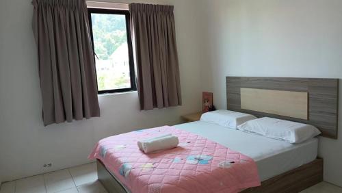 パンコールにあるWalking Distance To The Beach, Pangkorのベッドルーム1室(ピンクの毛布付きの大型ベッド1台付)