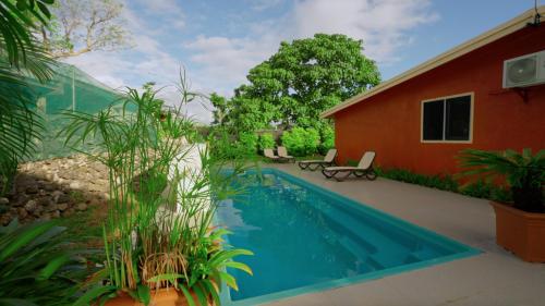 a swimming pool in front of a house at Elluk East Studios in Port Vila
