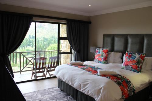 una camera con letto e un balcone con vista di Sunbird Haven Self-Catering Sleeps 8 a Clarens