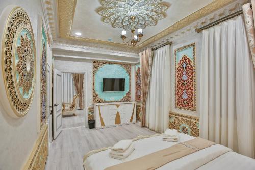 Un dormitorio con una cama grande y una lámpara de araña. en Asian Plaza, en Bukhara