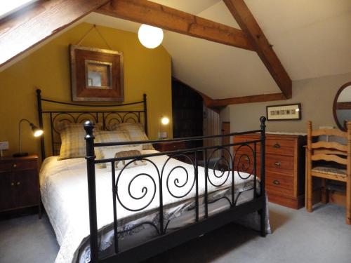 a bedroom with a black bed in a attic at Ryvington Apartments in Abergavenny