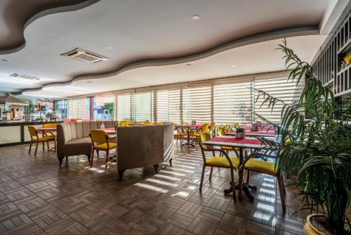 um restaurante com mesas, cadeiras e plantas em City Live Hotel em Antalya