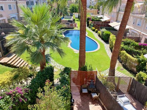 uma vista aérea de um resort com uma piscina e palmeiras em Cheerful Townhouse Center Sitges 5 bedrooms Pool and Terrace em Sitges
