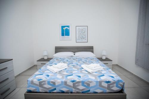 um quarto com uma cama com um edredão azul e branco em Casa ToRi em Siracusa