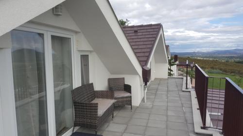 a balcony of a house with chairs on it at ARDO Élménybirtok in Balatonederics