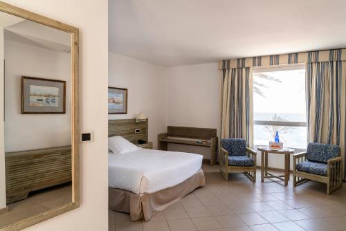 una camera d'albergo con letto e specchio di Parador de Jávea a Jávea