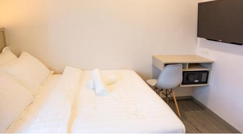a bedroom with a bed and a desk and a chair at THE CROWN HOTEL @ KLIA in Sepang