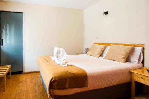a bedroom with a large bed with white sheets at Le Foyer Arequipa in Arequipa