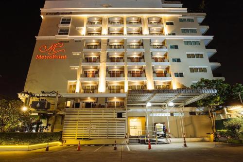 a large white hotel at night with its lights on at Metro Point Bangkok in Bangkok