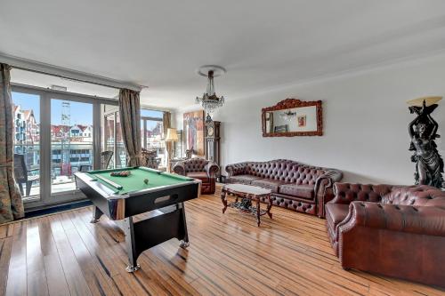 a living room with couches and a pool table at Waterlane Riverside - SPA, Pool, Gym & Parking by Downtown Apartments in Gdańsk