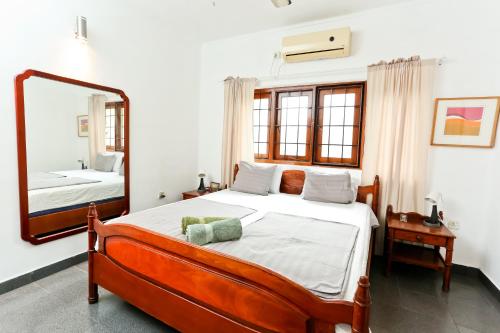 a bedroom with a large bed and a mirror at Maria Villa in Negombo