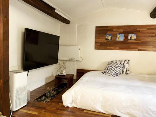 a bedroom with a bed and a flat screen tv at Viva La Vida - Jongno Hanok Private House in Seoul