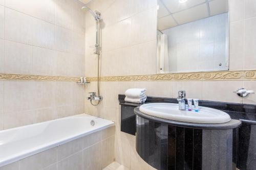 a bathroom with a sink and a bath tub at Icon Casa Living - Classy High Floor - Elite Residence in Dubai