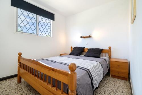 ein Schlafzimmer mit einem Holzbett und einem Fenster in der Unterkunft Villa La Palmera in Cambrils