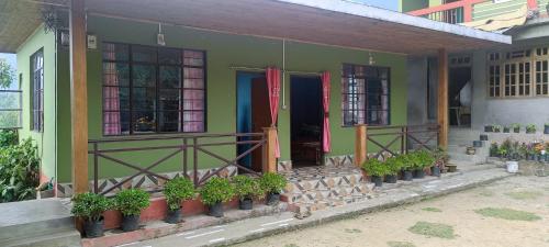 a house with potted plants on the front of it at 3 Sisters' Homestay in Ravangla