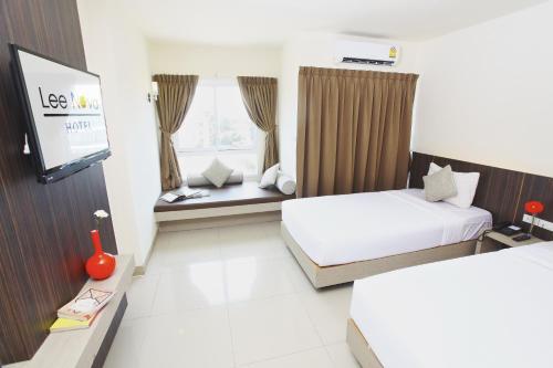 een hotelkamer met 2 bedden en een flatscreen-tv bij Leenova Hotel in Bangkok