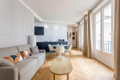 un salon avec un canapé et une table dans l'établissement Reva Suites, à Paris