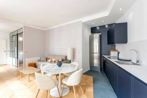 une cuisine avec une table et des chaises dans une pièce dans l'établissement Reva Suites, à Paris