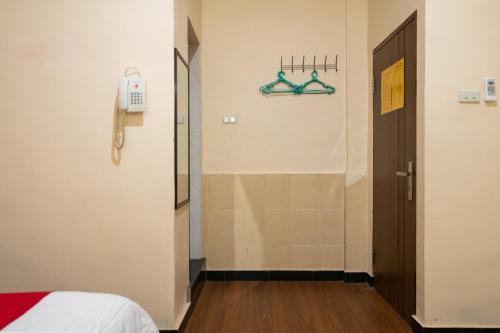 a room with a bed and a phone on the wall at RedDoorz Plus near Ramayana Pematangsiantar in Pematangsiantar