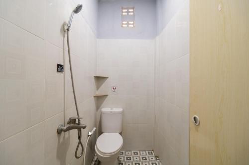 a small bathroom with a toilet and a shower at RedDoorz Plus near Ramayana Pematangsiantar in Pematangsiantar