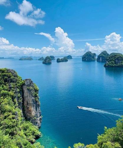 a boat in a large body of water with islands at Connexion in Ko Yao Noi