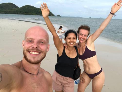 a man and two women standing on the beach at Connexion in Ko Yao Noi