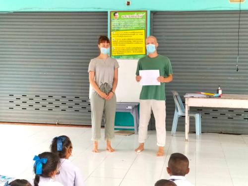 two people wearing face masks in front of a group of children at Connexion in Ko Yao Noi
