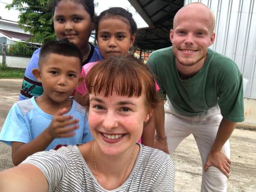 a man and a group of children posing for a picture at Connexion in Ko Yao Noi