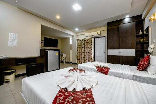 a hotel room with two beds and a kitchen at Gold Airport Suites in Lat Krabang