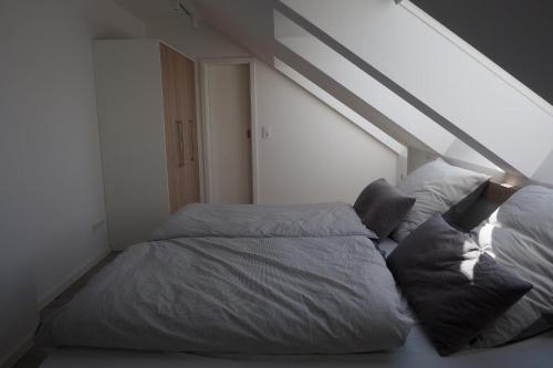 een slaapkamer met 2 bedden op een zolder bij Pilsumer Sternekieker in Krummhörn