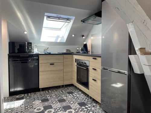 a kitchen with stainless steel appliances and a skylight at Les paddocks du dock I - Appart tout confort in Calais