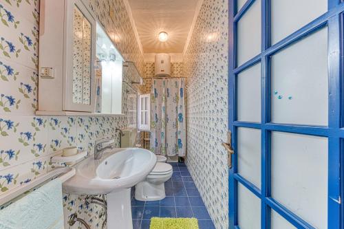 łazienka z umywalką, toaletą i niebieskimi drzwiami w obiekcie Villa Tulipano w mieście Torre Pali