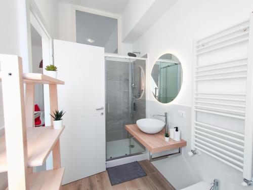 biała łazienka z umywalką i lustrem w obiekcie S&M Apartments "Casa Gemma" - Cimiano M2 w Mediolanie