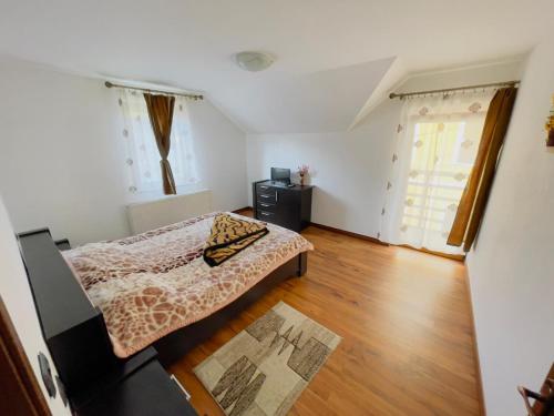 um pequeno quarto com uma cama e uma janela em Vila Felicia em Borşa
