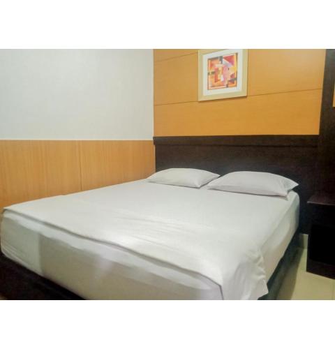 a bed with white sheets and pillows in a room at Homestay Akik Hijau Near Panakkukang in Pampang