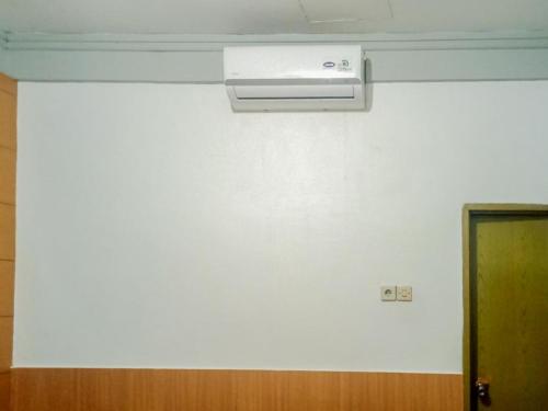 a white wall with a air conditioner in a room at Homestay Akik Hijau Near Panakkukang in Pampang