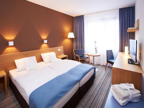 a hotel room with a large bed and a desk at Hotel Zugbrücke Grenzau GmbH in Höhr-Grenzhausen