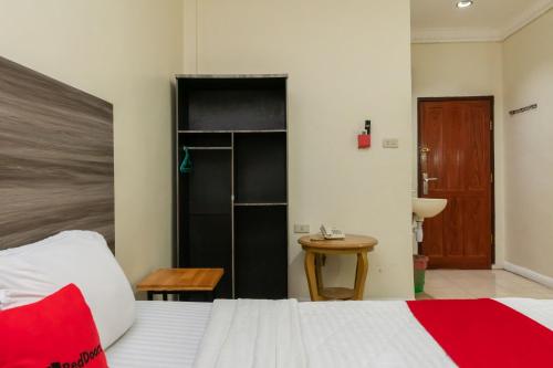 a bedroom with a bed and a wooden table at RedDoorz @ Pematangsiantar in Pematangsiantar