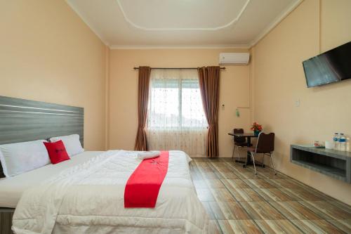 een hotelkamer met een bed en een raam bij RedDoorz @ Pematangsiantar in Pematangsiantar