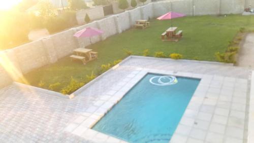 an overhead view of a swimming pool with tables and umbrellas at LEGENDS EXECUTIVE LODGE in Choma