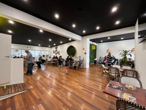 a group of people sitting in a room with wooden floors at Minlaton Hotel in Minlaton